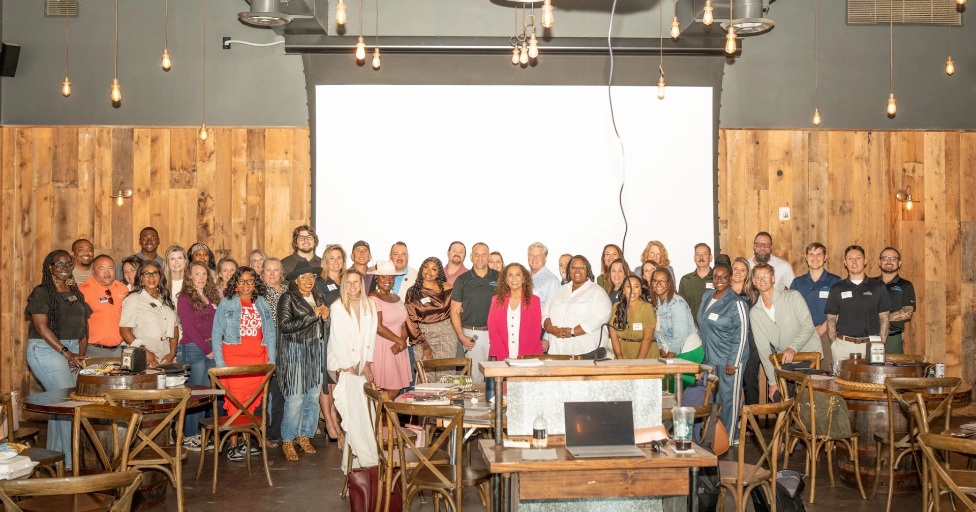Suha Beidas Zehl, CMB®, AMSP™ with attendees at a wood-paneled conference venue