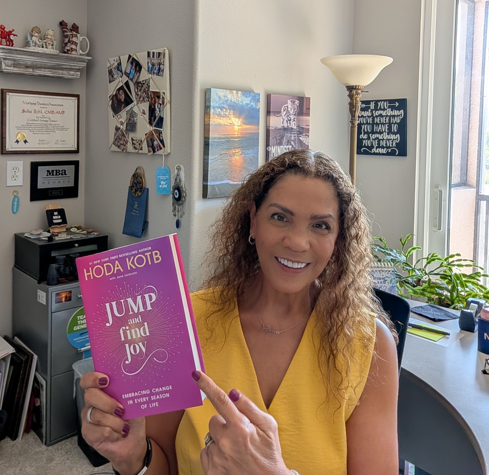 Suha Beidas Zehl, CMB®, AMSP™ holding a book in her office