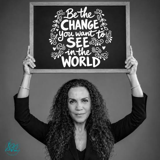 Suha Beidas Zehl holding a sign reading Be the change you want to see in the world
