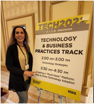 Suha Beidas Zehl, CMB®, AMSP™ beside her MBA Tech session sign on driving technology adoption